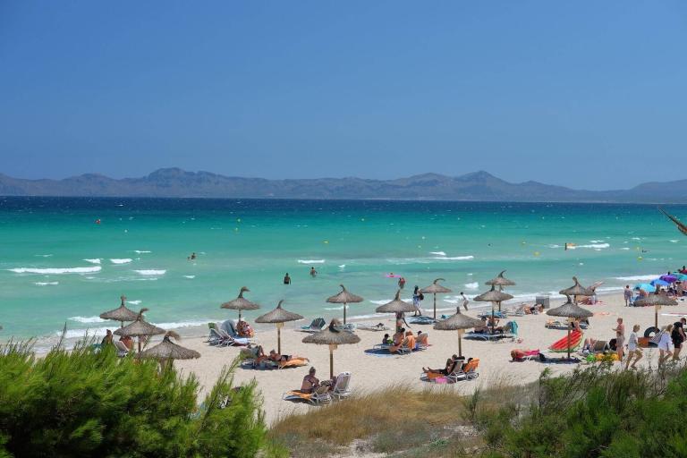 A Beach With Umbrellas And People On It